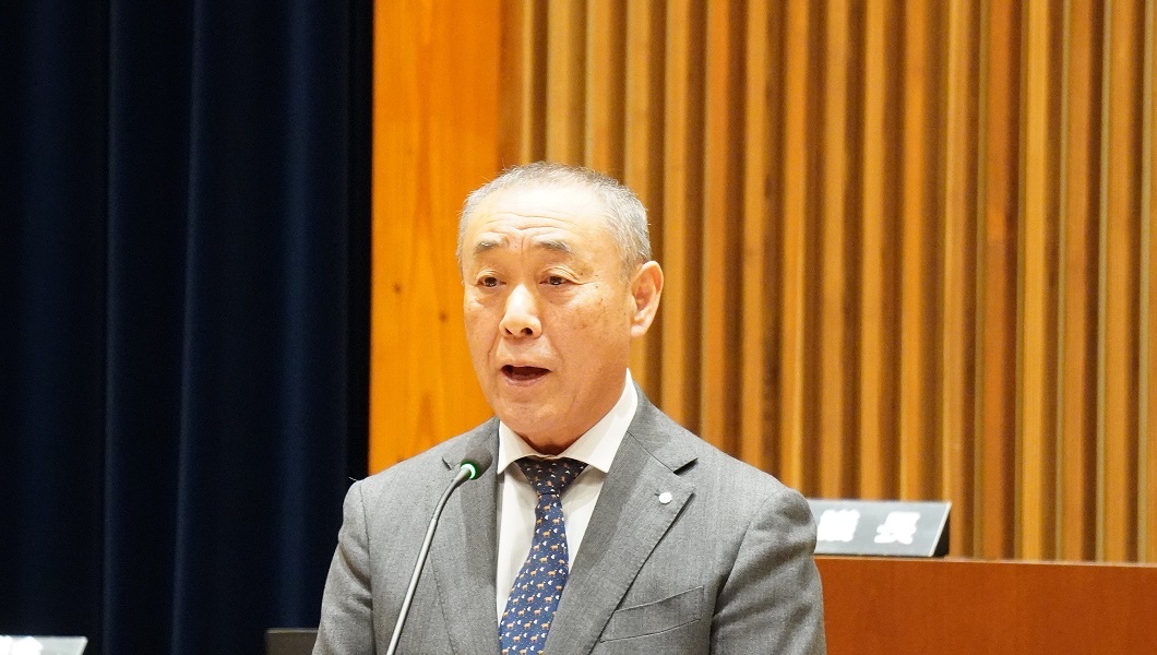 マイクの前で話をしている村長の写真